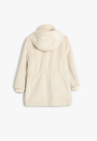 Manteau en fausse fourrure couleur crème avec capuche, taille élastique et poignets côtelés. Matériau texturé et doux avec une finition lisse. Vue arrière montrée.