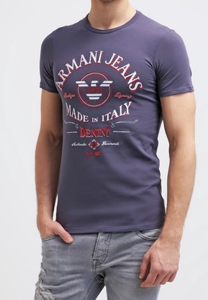 T-shirt marine ajusté à manches courtes avec col rond. Présente le logo coloré "Armani Jeans" et du texte en rouge et blanc. Confectionné en mélange de coton.