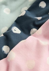 Drei Stücke Stoff in Pastellfarben—hellblau, marineblau und rosa—mit unregelmäßigen, hellen Polka-Dots und einer sanften Textur.