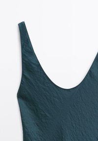 Costume da bagno color verde scuro realizzato in un tessuto morbido e leggermente strutturato, con scollatura profonda e spalline larghe.