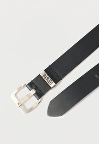 Czarny skórzany pasek z srebrną metalową klamrą i logo jako akcentem. Gładka faktura, klasyczny design i zakończenie w kształcie ostrego czubka.