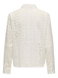 Chemise blanche à manches longues avec col présentant des motifs floraux et carrés découpés complexes sur tout le tissu, vue de dos.