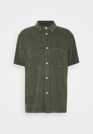 Chemise à manches courtes vert olive avec col et poche poitrine, en tissu doux et texturé.