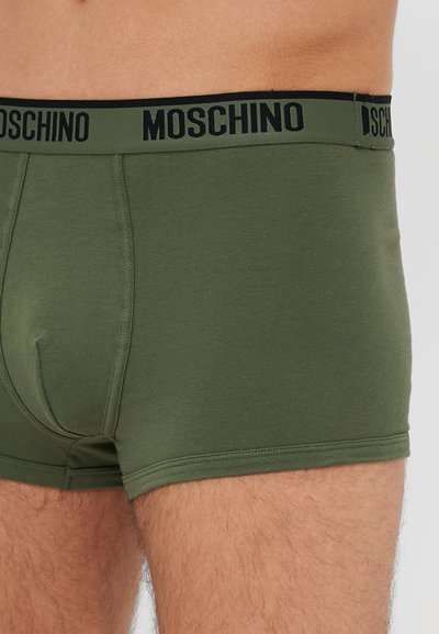 Olive zelene bombažne bokserice s črnim pasom z logotipom "MOSCHINO", ki se odlikujejo po tesnem prileganju in gladki teksturi. Dvojno šivane šive.