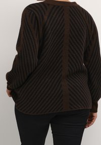 Brauner Strickpullover mit diagonalen schwarzen Streifen, lockerer Passform und langen Ärmeln, mit rundem Ausschnitt und einem etwas längeren Rückenteil.