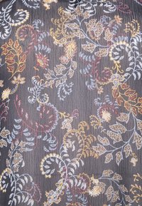 Tessuto nero con intricati motivi floreali multicolore in oro, rosso e azzurro chiaro, caratterizzato da una superficie textura e contorni dettagliati.
