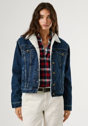 Jeansjack met een witte, sherpa-voering aan de kraag. Voorzien van versleten blauwe stof, voorzakken, metalen knopen en een cropped ontwerp.