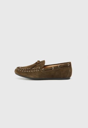 Brune suedesko med rund tå, dekorativ snøring og metallakkenter på sidene. Glatt tekstur og slip-on design.
