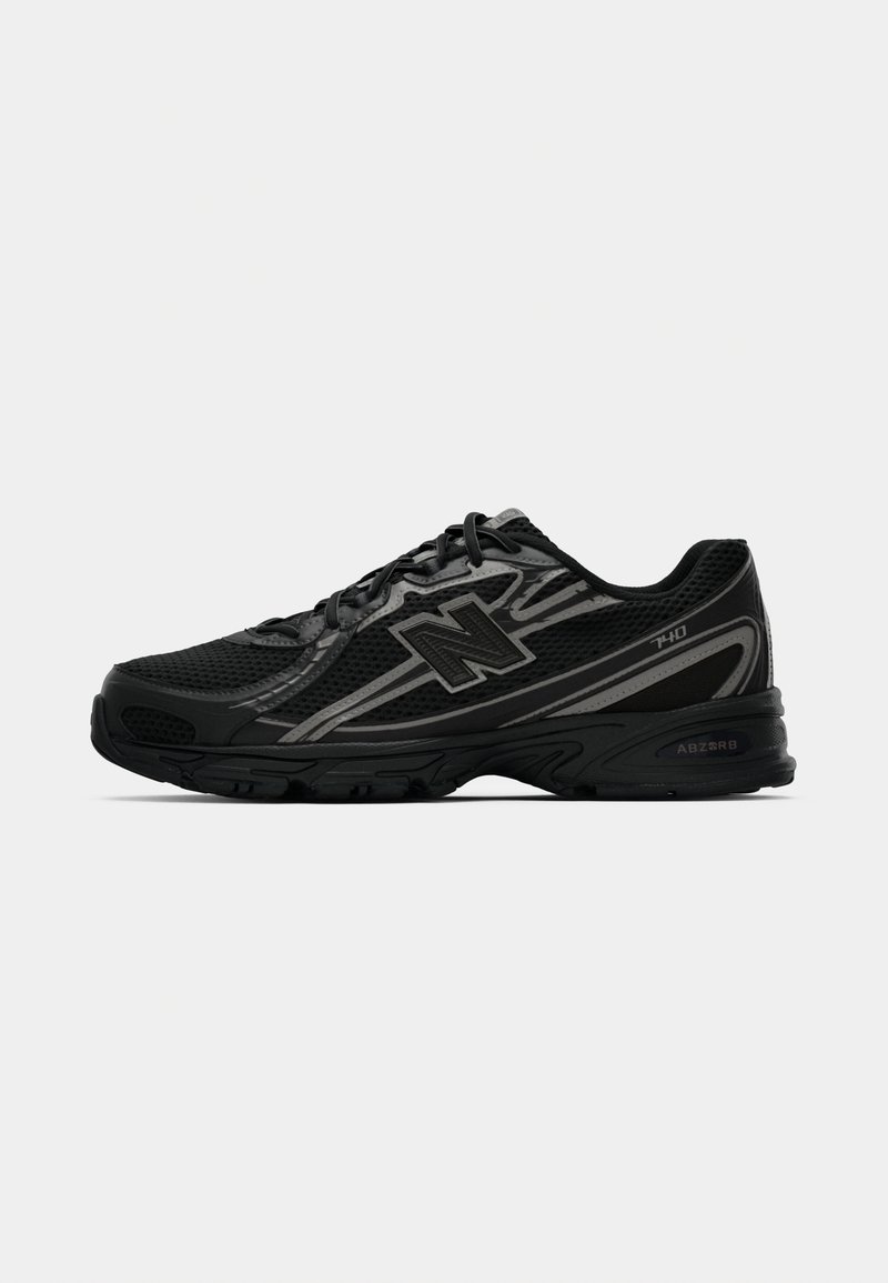 Shoe atlético preto com parte superior em malha, detalhes cinzentos e sola texturizada. Apresenta atacadores, design curvado e marcação na lateral.