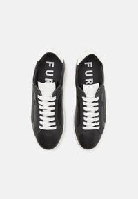 Sneaker nere in pelle con lacci bianchi e punta bianca. Logo "FURLA" stampato sulle solette, texture liscia, design casual.