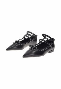 Scarpe nere flat con punta affusolata, adornate con cinturini borchiati. Realizzate in pelle liscia, con tacco basso e dettagli con fibbie.