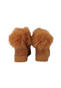 Stivali alla caviglia in suede marrone con grandi pompon di pelliccia beige sul retro, suola in gomma piatta e dettagli cuciti.