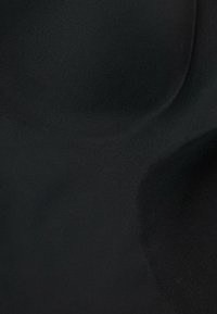 Tissu noir au toucher lisse, présentant des courbes et des contours doux, mettant en valeur sa forme flexible et son design sans couture.