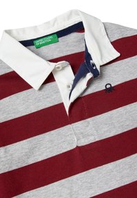 Czerwono-szara koszulka polo w paski z białym kołnierzykiem, granatowymi akcentami, dwoma guzikami przy szyi oraz haftowanym logo na piersi.