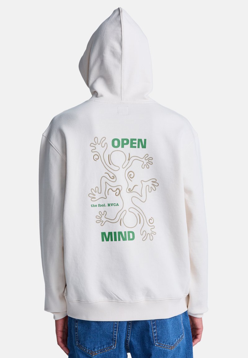 Biała bluza z kapturem z abstrakcyjną grafiką dwóch postaci oraz zielonym napisem "OPEN MIND" i "the fool. RVCA" na plecach, noszona z niebieskimi dżinsami.