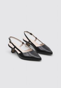 Escarpins noirs en cuir à bout pointu avec de petits talons carrés et des brides ajustables en doré.