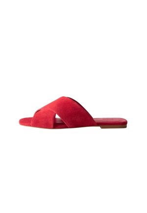 Sandale plate en daim rouge avec larges brides croisées et semelle fine, vue de profil sur fond blanc.
