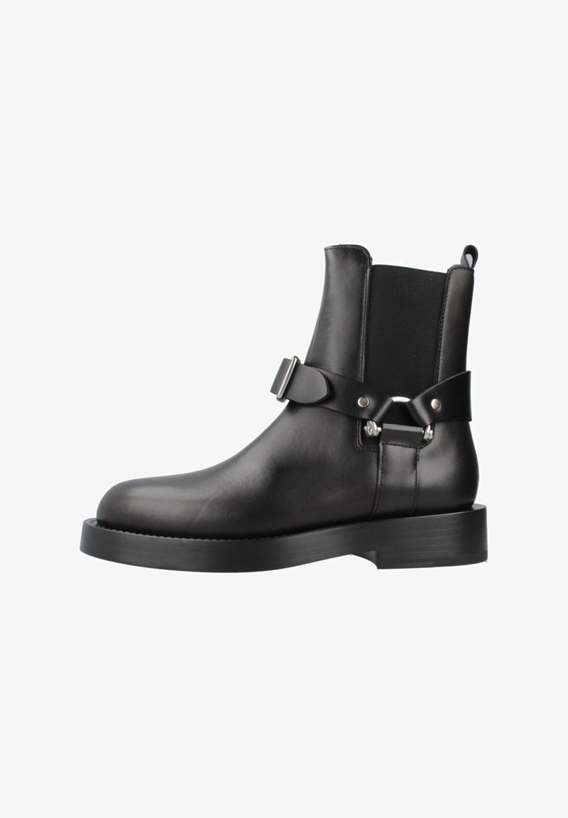 Botines de cuero negro hasta el tobillo con paneles laterales elásticos, puntera redondeada y una hebilla decorativa en el lateral; suela plana de goma.