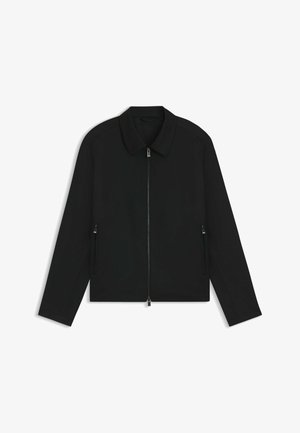 Giacca nera con zip, caratterizzata da colletto, maniche lunghe, due tasche laterali e una texture liscia e leggera. Design minimalista.