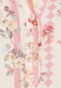 Blomstrede skjorte med knapper, der har en cremefarvet baggrund med pink striber og geometriske mønstre, blødt materiale og runde, klare knapper.