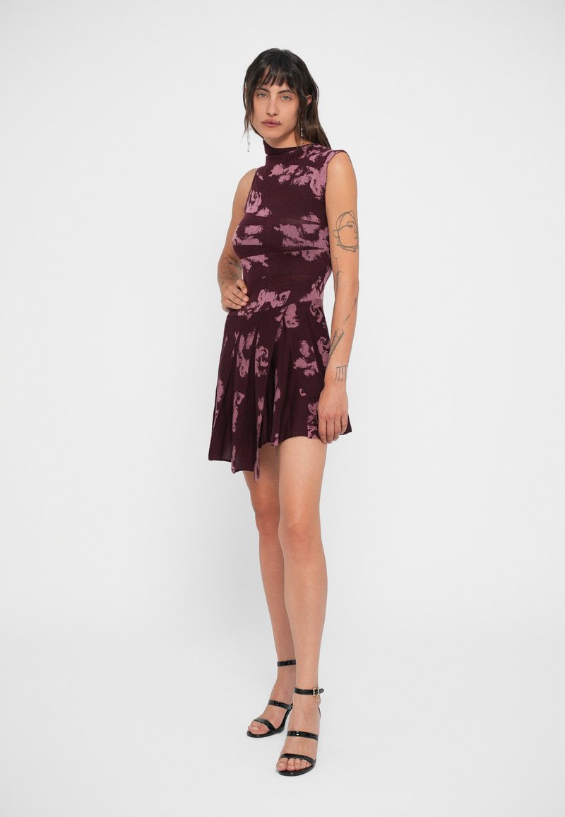 Burgundy klänning med blommönster, ärmlös design och utsvängd kjol. Matchas med svarta remsandaler. Slät, texturerad tyg.