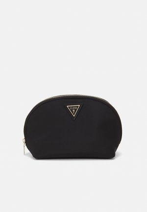 Pochette cosmetica nera con zip, forma arrotondata, realizzata in morbido tessuto, con logo triangolare dorato e dettaglio della zip. Design compatto.