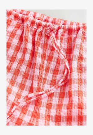 Tessuto a quadretti rosso e rosa con una vita elastica regolabile, caratterizzato da un aspetto texturizzato e sgualcito e un materiale morbido e leggero.