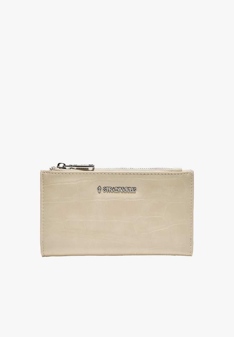 Portefeuille rectangulaire beige avec texture crocodile, fermeture éclair argentée et logo métallique Stradivarius au centre avant.