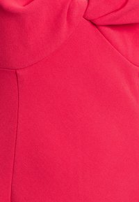 Tessuto rosa con una finitura liscia e leggermente testurizzata. Presenta una sezione superiore arricciata, creando una morbida caduta. Nessun motivo o accessorio visibile.