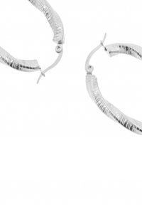Srebrne kolczyki-koła z teksturowaną, żebrowaną powierzchnią i prostym zapięciem na zatrzask. Mają owalny kształt i polerowane wykończenie.