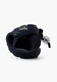 Chaussures noires en matériau flexible, dotées d'une surface texturée, d'un logo bien visible et d'un système de fermeture à cordon élastique pour ajuster l'ajustement.