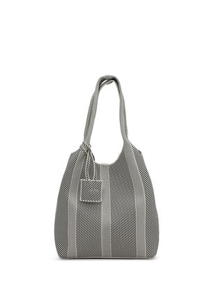 Torba na ramię w czarno-białe paski z dwoma długimi uchwytami oraz małą przypiętą kwadratową saszetką zawieszoną na jednym z pasków.