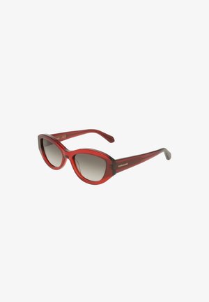 Lunettes de soleil rouges translucides de forme œil de chat avec des verres dégradés foncés et le logo Ferragamo sur les branches.