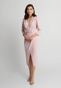 Różowa dopasowana sukienka z głębokim dekoltem w kształcie V, rękawami o długości trzy czwarte i rozcięciem po boku; wykonana z gładkiego materiału o strukturalnym designie.