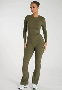 Olivenfarbendes Langarmoberteil und ausgestellte Hose, aus dehnbarem Stoff gefertigt. Verfügt über ein tailliertes Design mit glatter Textur, geeignet für Sportbekleidung.