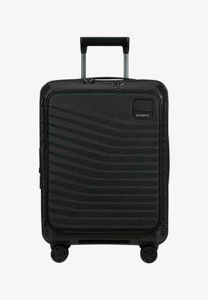 Valise rigide noire avec poche zippée à l'avant, poignée télescopique, quatre roues et logo Samsonite dans le coin supérieur droit.