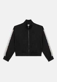 Sort cropped zip-jakke med høj krave, der har hvide stribede detaljer og tekstureret udsmykning langs ærmerne. Blødt stof, afslappet pasform.