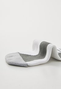 Grau-weiße Sportsocke mit einer strukturierten Oberfläche, kontrastierenden Farbblenden und einem gerippten Bündchen; aus einem Baumwoll-Synthesegemisch.