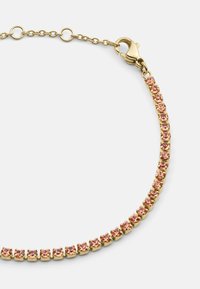 Bracciale color oro con una fila di gemme rosa, collegato con un gancio a moschettone e catena regolabile per la personalizzazione della lunghezza.