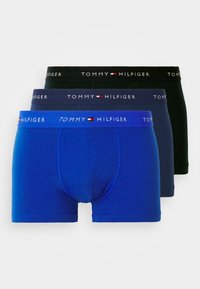 Három pár bokszernadrág kék, sötétkék és fekete színben, rugalmas szalaggal, melyen a "TOMMY HILFIGER" logo található, sima szövet textúrával.