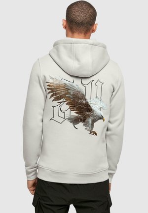 Light gray hoodie featuring a graphic of an eagle on the back, with intricate feather details and block lettering design. Cotton blend material.