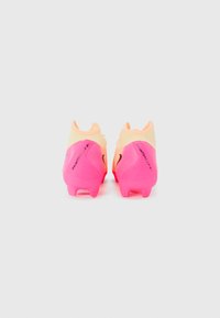 Bottes de foot brillantes en rose et jaune avec un design élégant, dotées d'une tige texturée, d'un talon moulé et de la marque Nike sur les côtés.