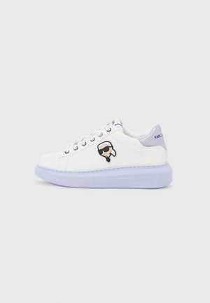 White sneakers with a smooth leather upper, round toe, and purple rubber sole. Features a cartoon character emblem on the side.