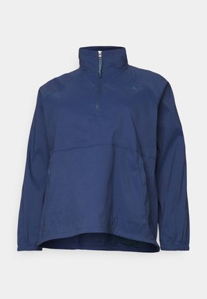 Polo de manga larga azul marino con cremallera hasta el pecho, cuello alto, puños elásticos y logo sutil en el pecho izquierdo.