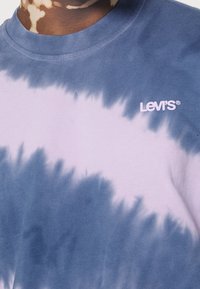 T-shirt tie-dye in blu e lavanda chiaro, realizzata in cotone, con maniche corte e scollatura rotonda, con il logo "Levi's" bianco.