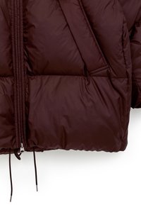 Burgundy puffer jacket featuring a smooth, shiny texture, angled quilted sections, front zipper closure, and adjustable drawstring at the hem.