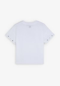 T-shirt en coton blanc avec des manches courtes et des œillets argentés, et un logo de skull brodé à l'arrière près de l'encolure.