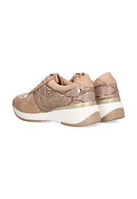 Zapatillas beige claro con paneles de textura acolchada y acentos lisos, con una suela cuña blanca y beige. Detalle metálico cerca del talón.