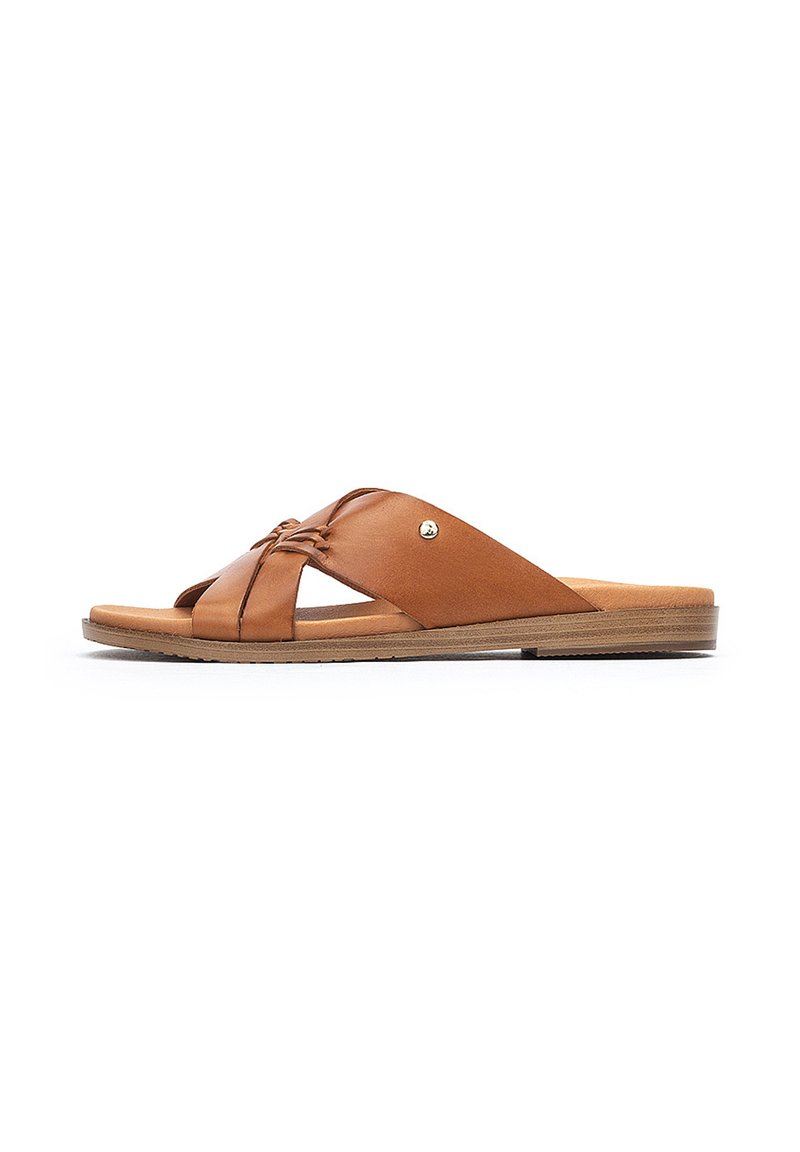 Sandalias de cuero marrón deslizantes con tiras cruzadas, diseño de punta abierta, suela plana, detalles de costura sutiles y un pequeño acento metálico.