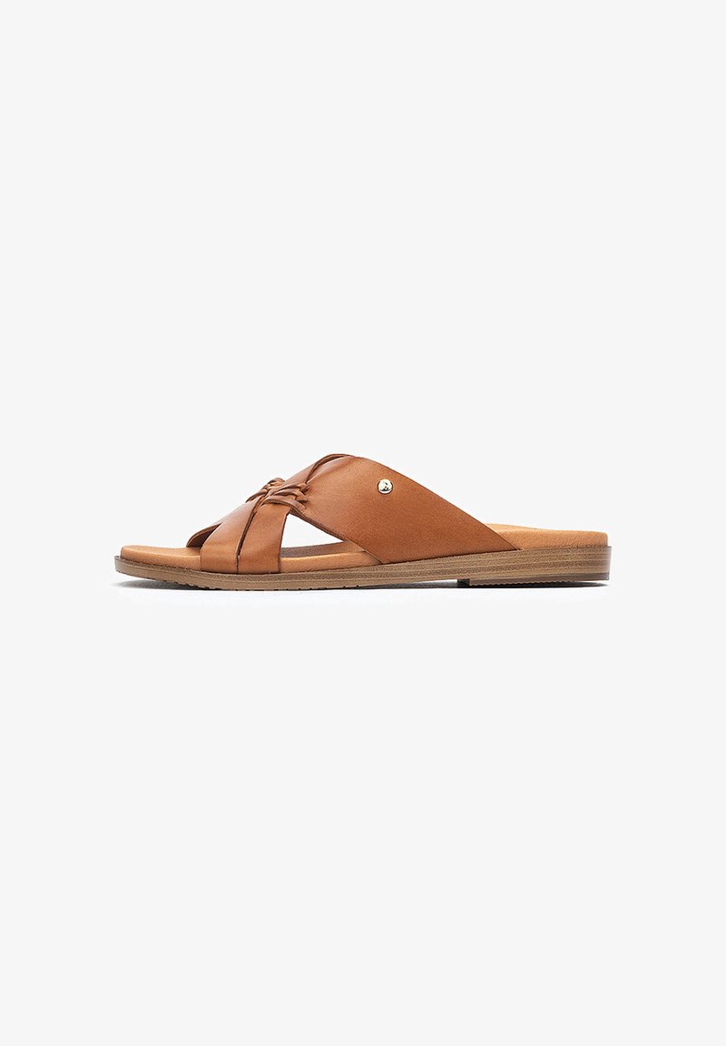 Sandales à glissière en cuir marron avec des sangles croisées, design à bout ouvert, semelle plate, détails de couture subtils et un petit accent en métal.